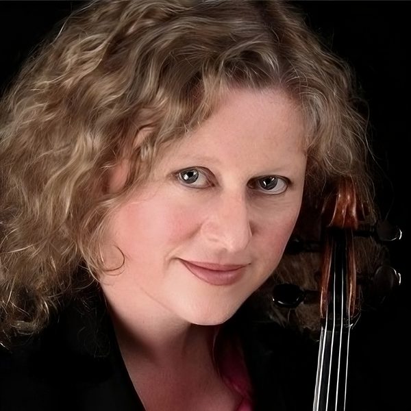 Portrait of Lorraine McAslan holding a violin against a black background.