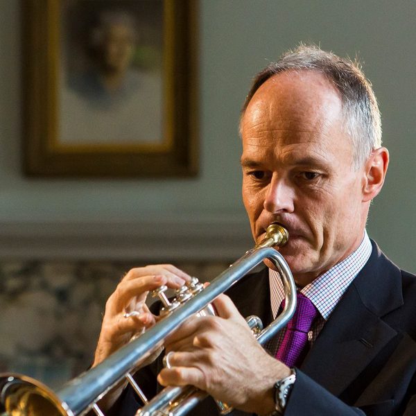 Mark David plays a trumpet.