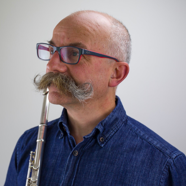 Michael Cox Stands side on to camera, holding a flute.