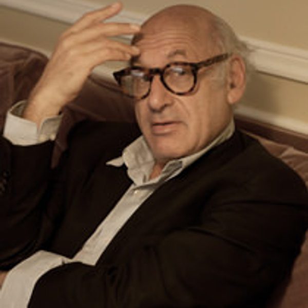 Michael Nyman sits down, looking to camera.