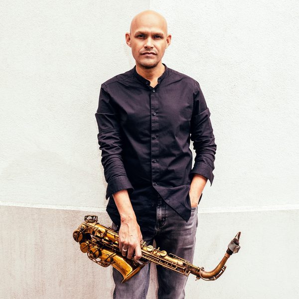 Miguel Zenon stands hand in pocket, holding a saxophone