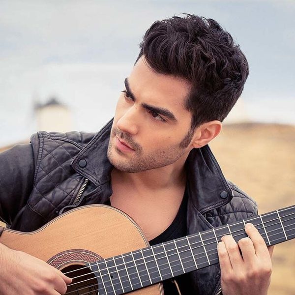 Miloš Karadaglić plays guitar outside.