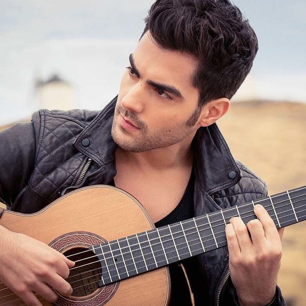 Miloš Karadaglić plays guitar outside.