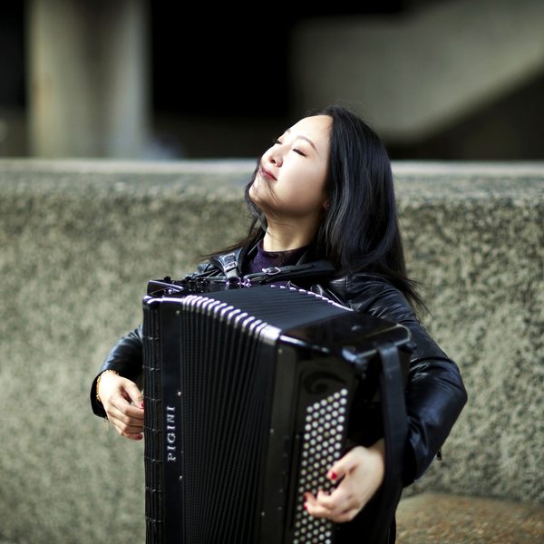 Mingyuan Ruan plays an accordion outside.