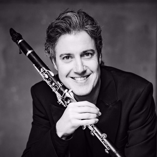 Patrick Messina poses for camera, holding a clarinet