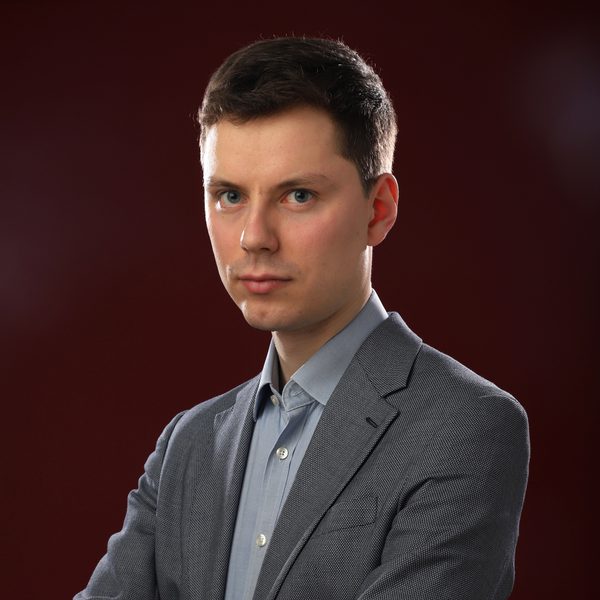 Portrait of Richard Gower looking to camera side-on with arms crossed.