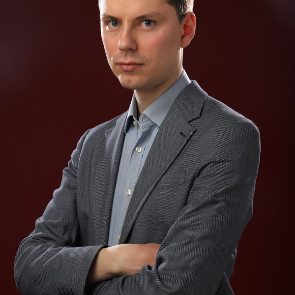 Portrait of Richard Gower looking to camera side-on with arms crossed.