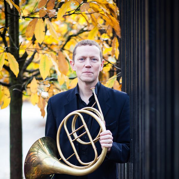 Roger Montgomery holds a horn outdoors.