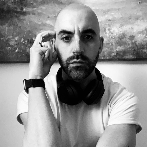 Rubens Askenar poses for camera, with hand held against the side of head.
