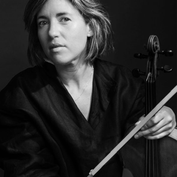 Ruth Gibson looks to camera, holding viola bow.