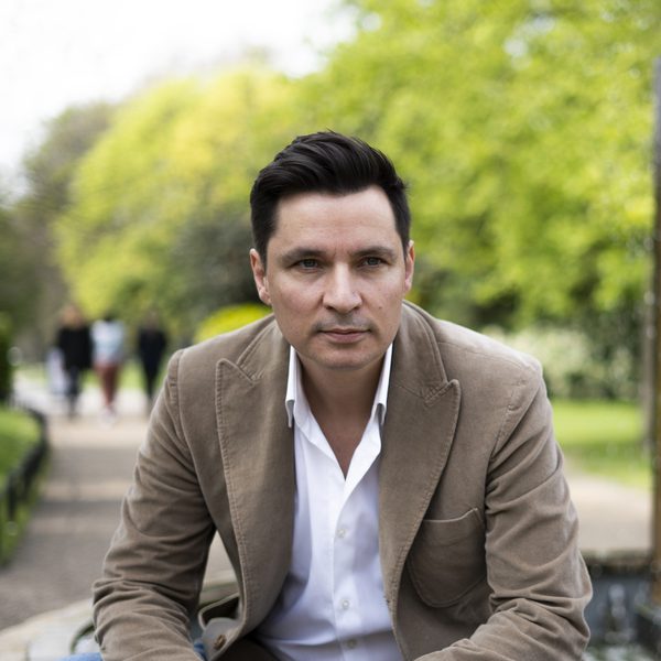 Portrait of Simon Lepper sitting outside, looking to camera.