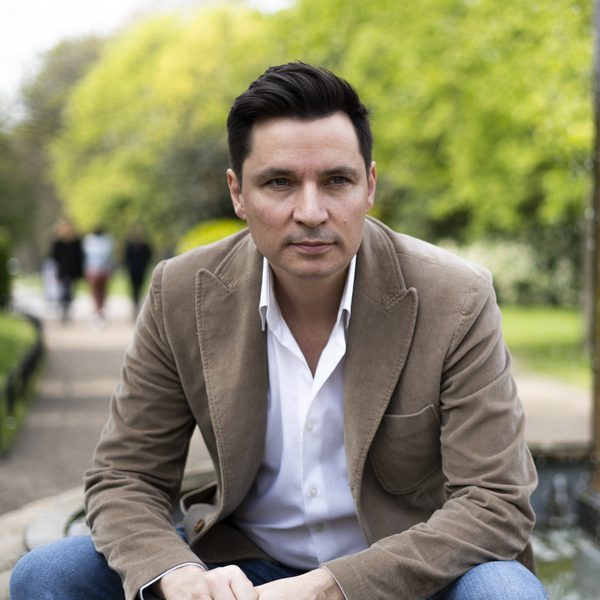 Portrait of Simon Lepper sitting outside, looking to camera.