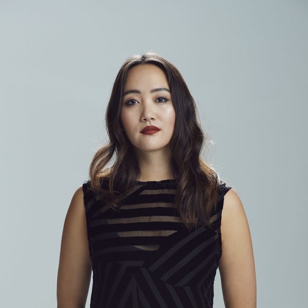 Somi Kim smiles to camera against a grey background.