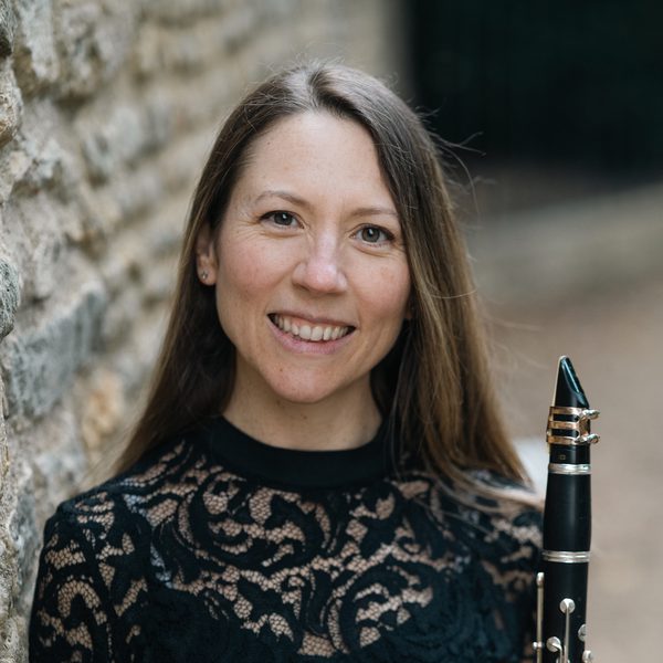 Sonia Sielaff poses for headshot outside, holding a clarinet.