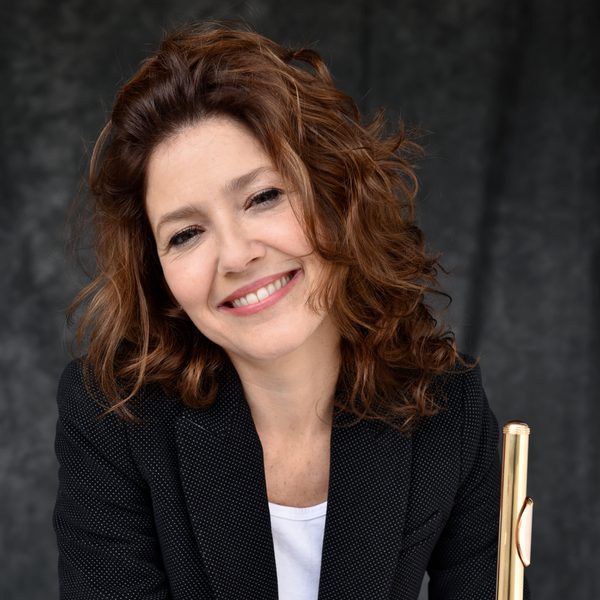 Portrait of Sylvia Careddu smiling to camera holding a flute