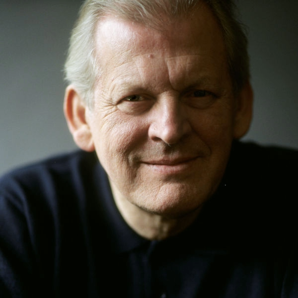 Thomas Allen smiles to camera with hands clasped.