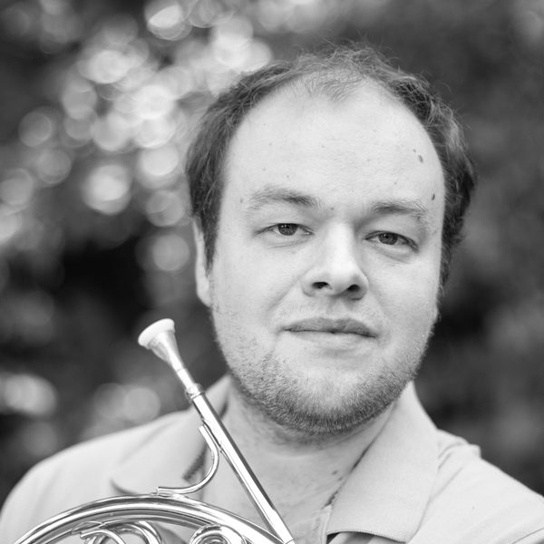 Portrait of Timothy Ellis holding a horn.