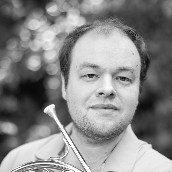Portrait of Timothy Ellis holding a horn.
