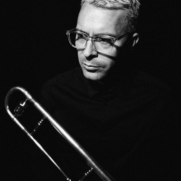 Side portrait of Trevor Mires holding a Trombone (black and white)