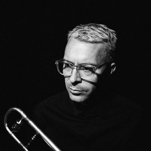 Side portrait of Trevor Mires holding a Trombone (black and white).