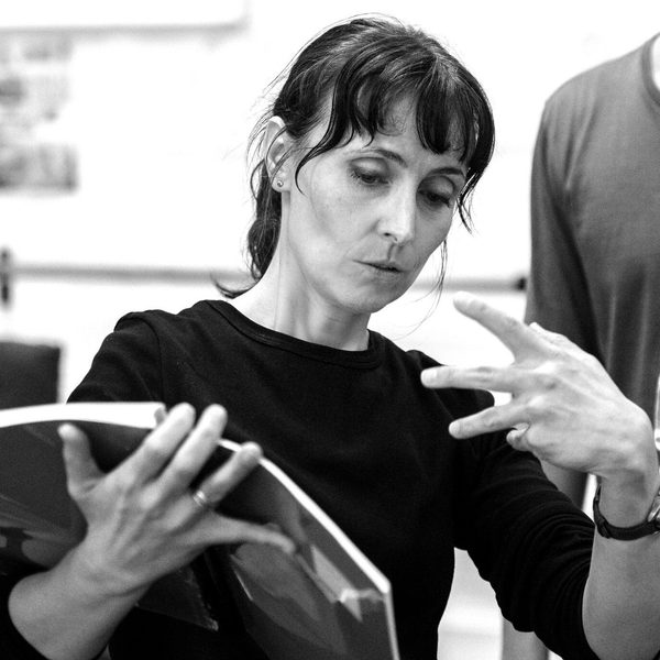 Victoria Newlyn gesticulates while reading from sheetmusic