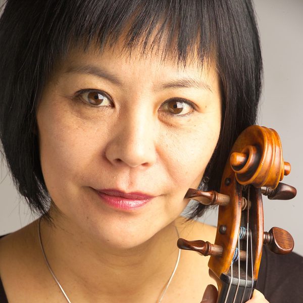 Close up portrait of Yoku holding her viola near to face.