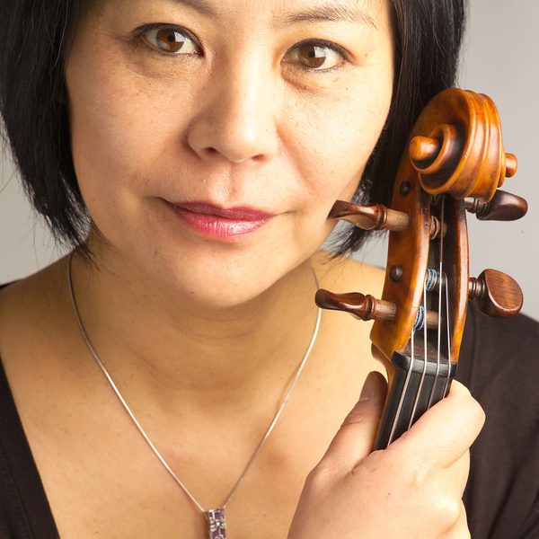 Close up portrait of Yoku holding her viola near to face.