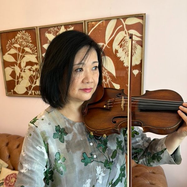 Yumi Sasaki plays violin, looking off-camera.