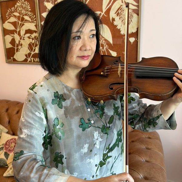 Yumi Sasaki plays violin, looking off-camera.