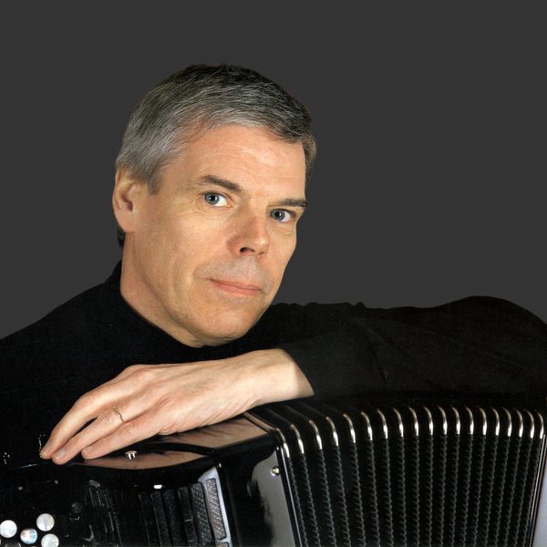 Owen Murray faces camera, with arm resting on top of an accordion