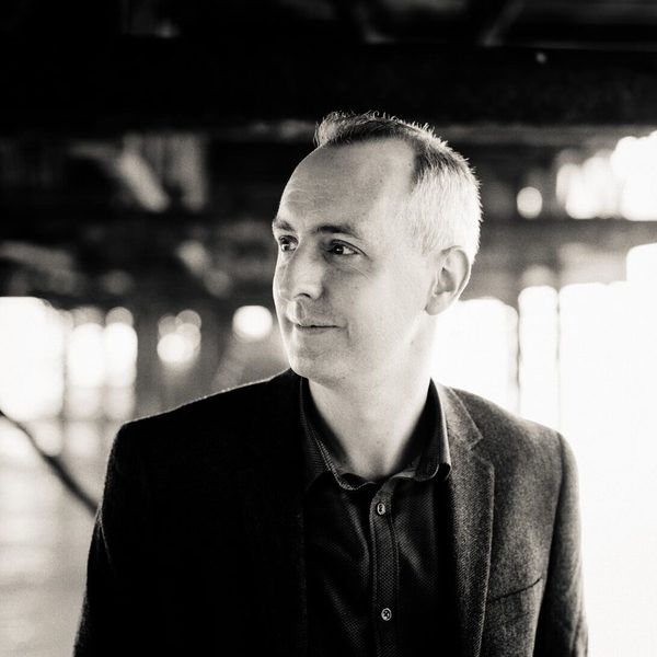 Side portrait of David Gorton in a well-lit outdoor space